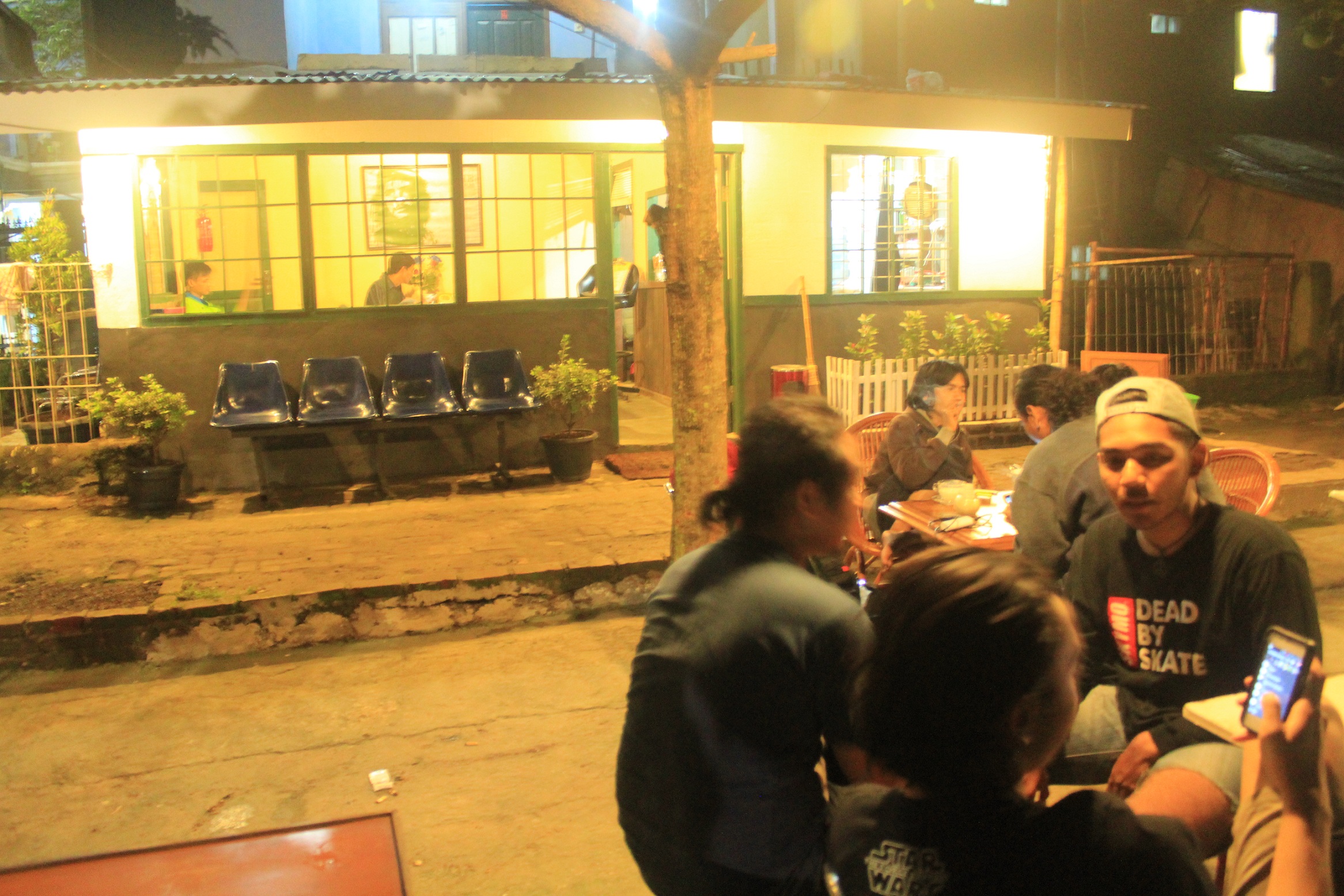 Suasana Kedai Greenwhite pada malam hari. beberapa pengunjung asyik berbincang sambil menikmati suguhan yang mereka pesan