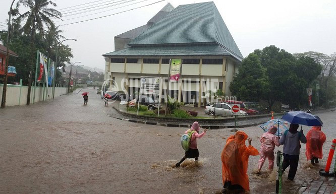 UIN Bandung Banjir -- Beberapa masyarakat melintasi jlan utama Kampus UIN SGD Bandung yang digenangi air akibat hujan deras, Sabtu (9/4/2016) tadi. Ini membuktikan drainase Kampus yang belum berfungsi maksimal. (Doni Anggola/ Magang)