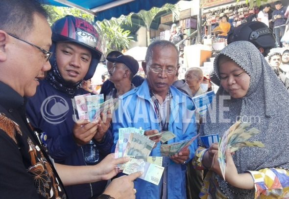 Deputi Direktur, Mikael Budisatrio melakukan sosialisasi uang baru kepada masyarakat di area perbelanjaan Pasar Baru, Kota Bandung, Selasa (20/12/16). (Restia Aidila Joneva / SUAKA)