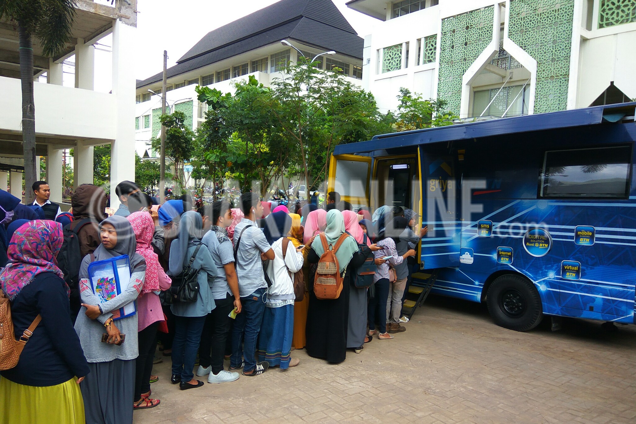 Mahasiswa sedang mengantre untuk melakukan pembayaran uang kuliah di ATM mobile banking Bank Tabungan Negara (BTN) bertempat di depan Fakultas Ushuludin, Senin (09/01/2017). (SUAKA/Dadan M. Ridwan)