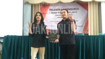 Presiden Mahasiswa (Presma) Domisioner, Adi Maulana Ibrahim (kiri) menyerahkan plakat sebagai simbolis dalam prosesi serah terima jabatan kepada Presma terpilih, Thoudy Badai Rif’anbillah (kanan) dalam acara Pelantikan Badan Eksekutif Mahasiswa Jurusan (BEM-J) Jurnalistik periode 2016-2017, Kamis (9/2/2017). (Edi Setio /Magang)