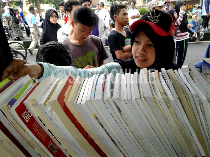 Berbagi Buku: Pengunjung mengambil buku di mobil perpustakaan keliling, Minggu (22/5/2016) di Jl Ir H Djuanda, Kota Bandung.  Dalam rangka memperingati Hari Buku Nasional Ikapi Jabar bekerjasama dengan Pemprof Jabar membagikan ribuan buku secara gratis untuk meningkatkan minat membaca buku bagi masyarakat. (SUAKA/Dede Lukman)