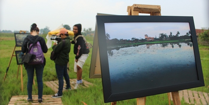 Pengunjung sedang melihat foto-foto yang ditampilkan dalam acara Pameran Fotografi Jurnalistik bertemakan "Tanah Kami Terpapar Limbah" yang diadakan oleh Komunitas Fotografi Jurnalistik UIN Bandung, Photo's Speak di Kampung Rancakeong, Desa Linggar, Kecamatan Rancaekek, Kabupaten Bandung, Minggu (5/5/2016). Pameran ini dipersembahkan untuk menggambarkan kegelisahan para anggota Photo's Speak akan kondisi lingkungan yang semakin hari semakin memburuk karena ulah dari beberapa pihak yang tidak bertanggung jawab. (SUAKA / Elya Rhafsanzani)