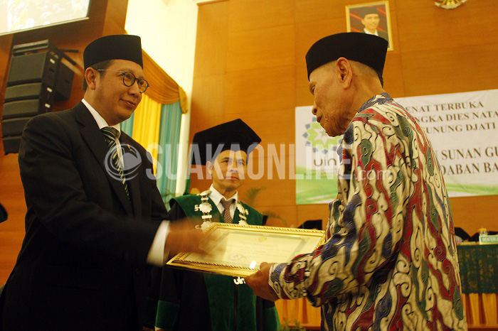 Menteri Agama Republik Indonesia Lukman Hakim Saifuddin memberikan piagam penghargaan kepada salah satu pendiri Universitas Islam Negeri (UIN) Sunan Gunung Djati (SGD) Bandung, Jum'at (8/4/2016) pada acara puncak Dies Natalis ke- 48 UIN SGD Bandung di Gedung Anwar Musaddad. Penghargaan ini sebagai salah satu bentuk apresiasi negara kepada pendiri UIN SGD Bandung. (Mohammad Aziz/ Magang)