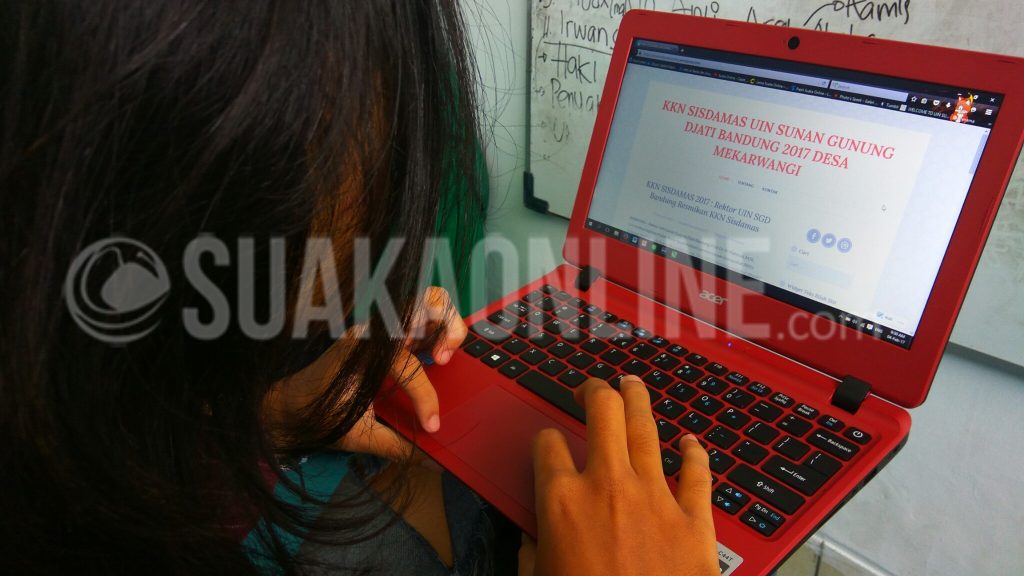 Seorang mahasiswa melihat blog KKN Sisdamas 2017 kelompok Desa Mekarwangi Kecamatan Haurwangi Kabupaten Cianjur. Blog KKN ini digunakan oleh tiga kelompok yang bertempat di satu desa. (Dadan M. Ridwan/ SUAKA)